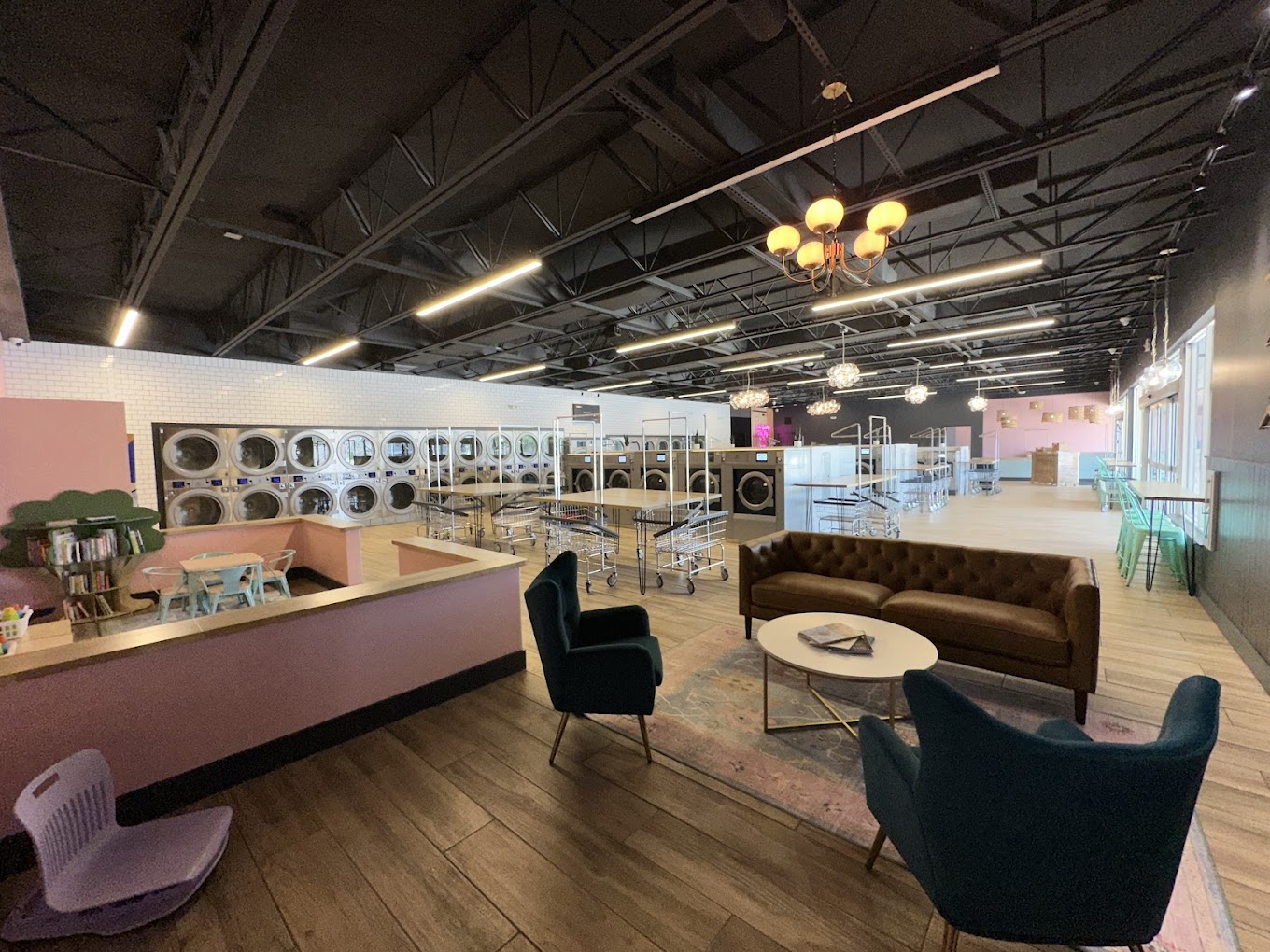 Open floor with the pink service counter, velvet sofa and chandeliers